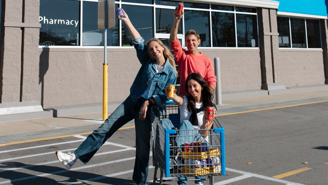 three people outside celebrating, holding cans of culture pop soda